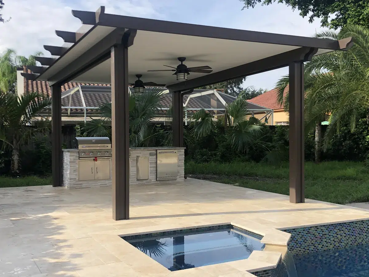 Covered outdoor kitchen with stone countertops and stainless steel grill