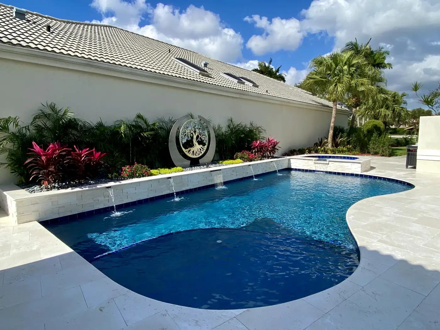 Covered outdoor kitchen with stone countertops and stainless steel grill