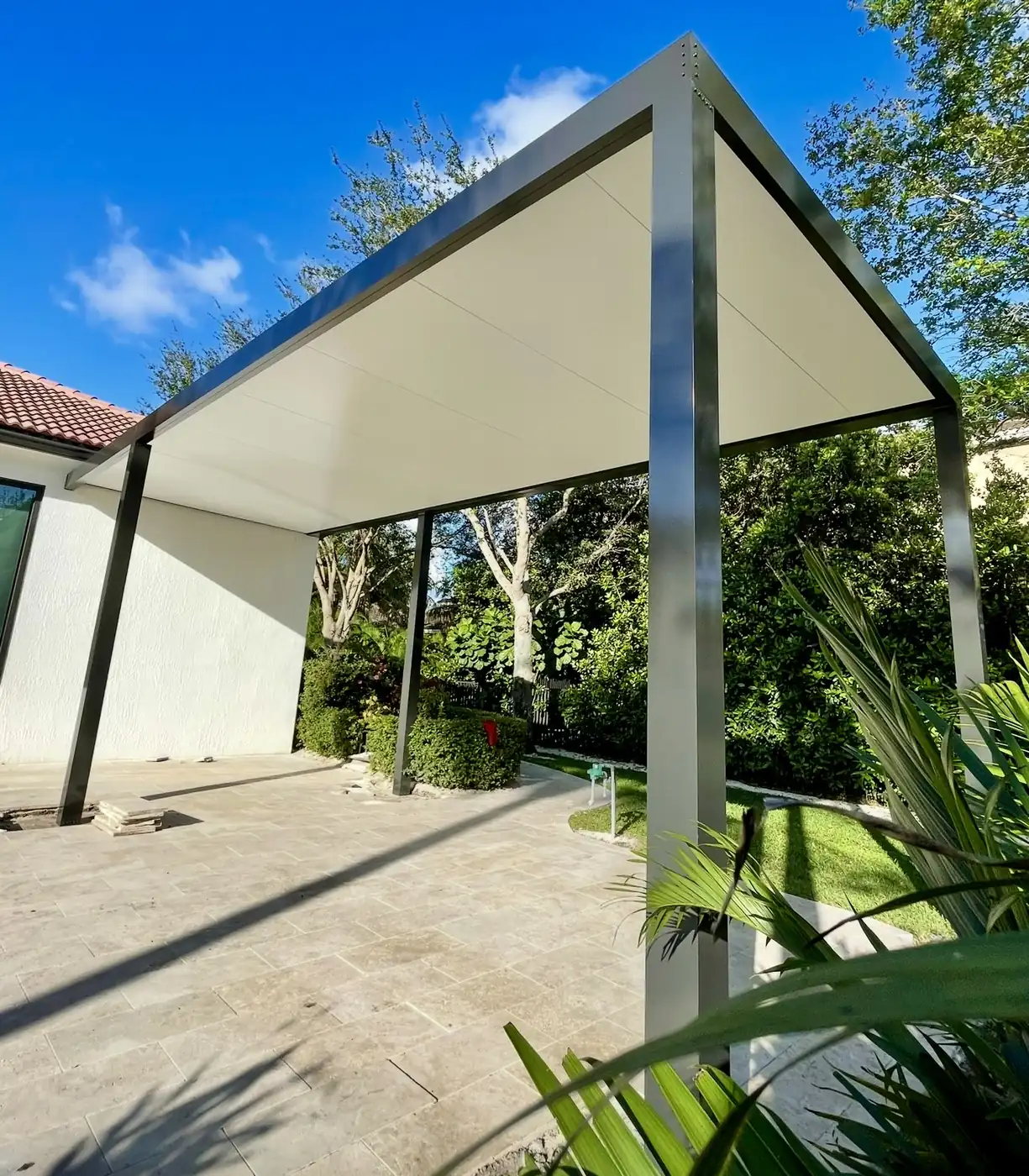 Modern shaded pergola structure beside an outdoor patio